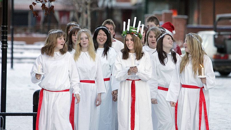 Dziewczyna przebrana za Świętą Łucję i jej pokojówki spacerują ulicami małego miasteczka Aange (Ånge), 400 km na północ od Sztokholmu