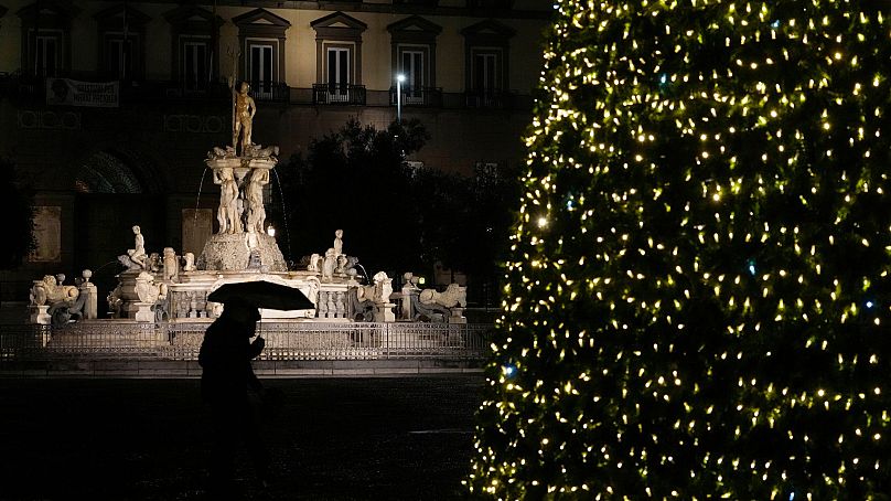 Tłem światełek choinki jest fontanna Neptuna w Neapolu, Włochy, grudzień 2021 r.