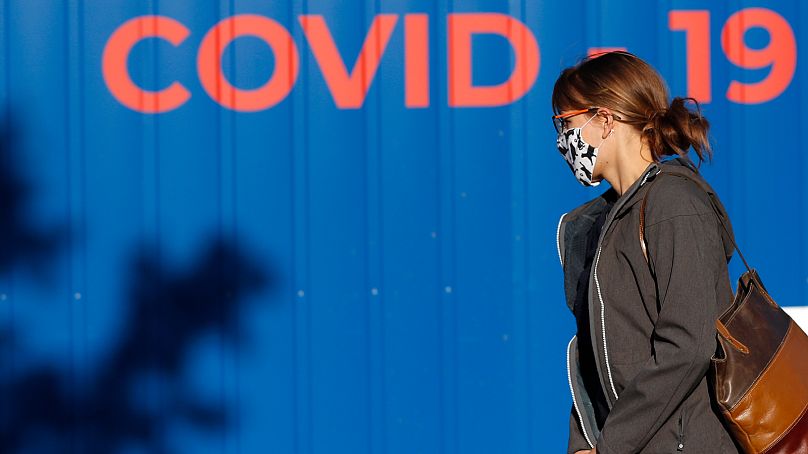 Kobieta w masce na twarzy idzie do Pragi w Czechach, aby poddać się testowi na obecność Covid-19.