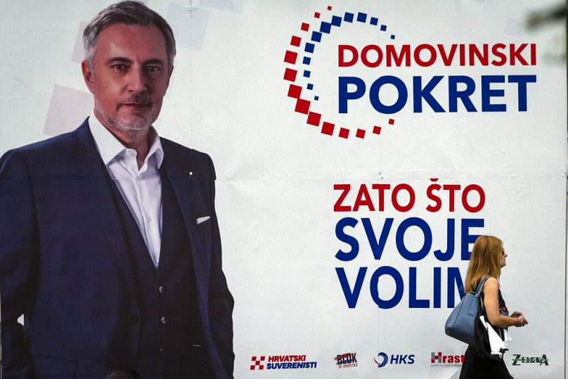 Kobieta przechodzi obok plakatu wyborczego Mirosława Skoro, piosenkarza ludowego i przywódcy prawicowego Ruchu Ojczyzny, w Zagrzebiu, lipiec 2020 r.