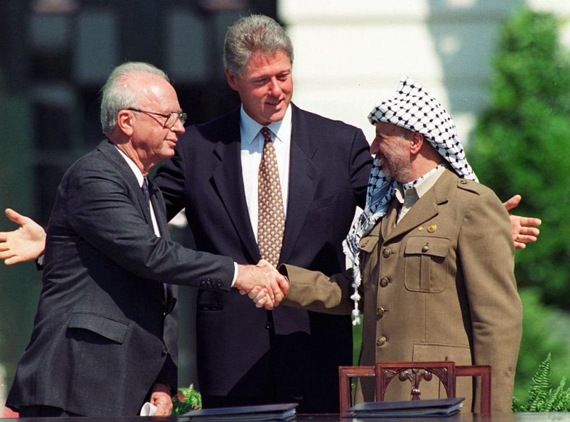 Izraelski premier Icchak Rabin i palestyński przywódca Jaser Arafat podają sobie ręce podczas podpisania porozumienia pokojowego w Waszyngtonie, wrzesień 1993 r.