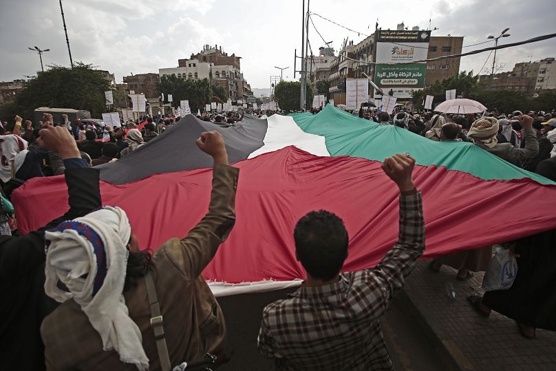 Zwolennicy Houthi trzymają flagę palestyńską podczas wiecu w Sanie, Jemen, 17 maja 2021 r.