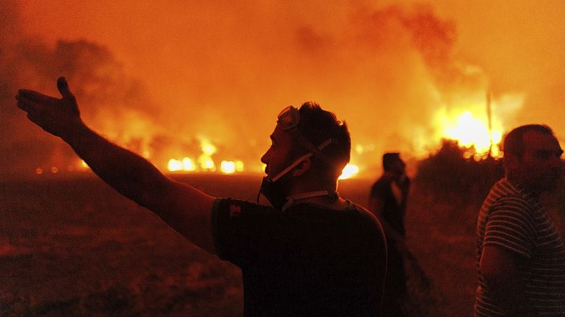 Ludzie reagują, gdy próbują ugasić pożar we wsi Avantas, niedaleko miasta Alexandroupolis, w północno-wschodnim regionie Evros w Grecji, 21 sierpnia