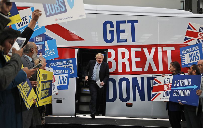 Premier Wielkiej Brytanii Boris Johnson przemawia do swoich zwolenników przed wejściem do autobusu jadącego na szlak kampanii przed wyborami powszechnymi w Manchesterze w Anglii, piątek, 15 listopada 2019 r.