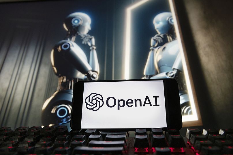 Logo OpenAI jest wyświetlane na telefonie komórkowym z obrazem na monitorze komputera wygenerowanym przez model zamiany tekstu na obraz Dall-E firmy ChatGPT, piątek, 8 grudnia 2023 r.