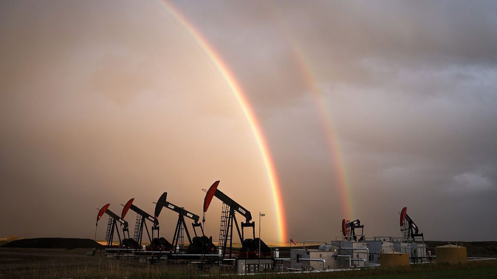 A rainbow appears to come down on pumpjacks drawing out oil and gas from wells near Calgary, Alberta, Monday, Sept. 18, 2023.