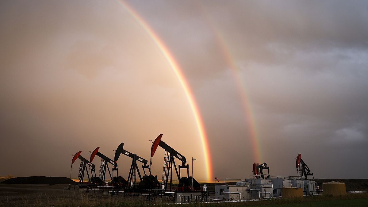 A rainbow appears to come down on pumpjacks drawing out oil and gas from wells near Calgary, Alberta, Monday, Sept. 18, 2023.