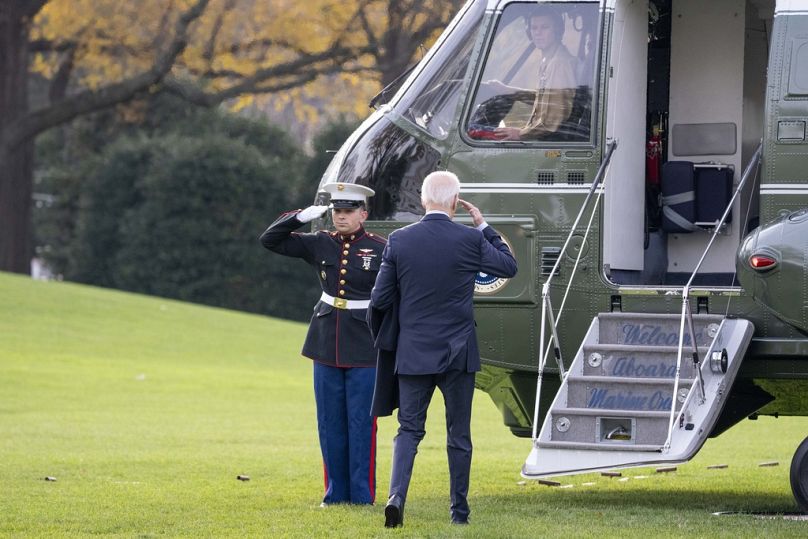 Prezydent Joe Biden salutuje, wchodząc na pokład Marine One i opuszczając południowy trawnik Białego Domu, grudzień 2023 r.