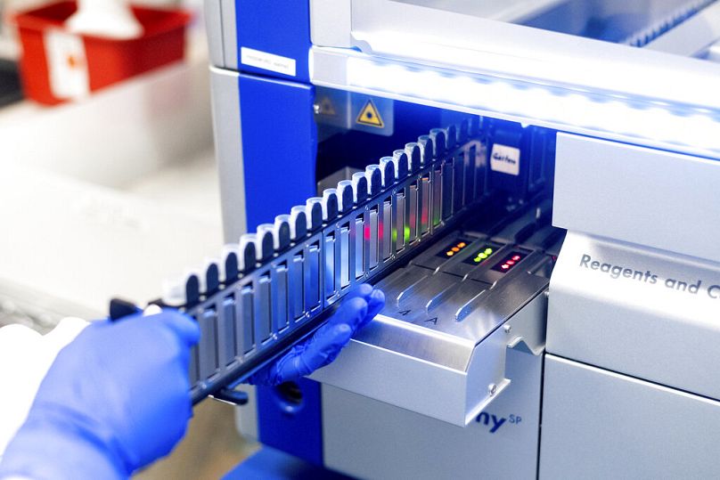 Naukowiec laboratoryjny przetwarza próbki górnych dróg oddechowych od pacjentów podejrzanych o zakażenie Covid-19 w Stanford Clinical Virology Laboratory w Palo Alto, luty 2021 r.