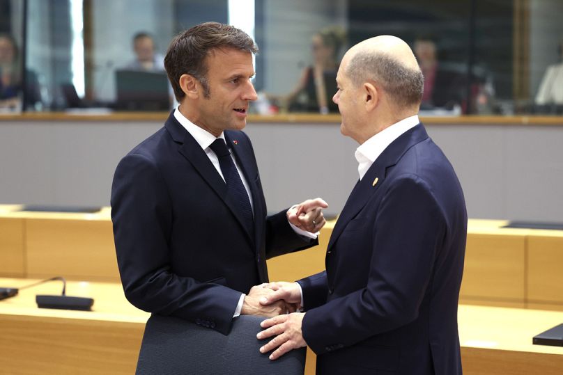 Prezydent Francji Emmanuel Macron rozmawia z kanclerzem Niemiec Olafem Scholzem podczas okrągłego stołu w budynku Rady Europejskiej w Brukseli, czerwiec 2023 r.