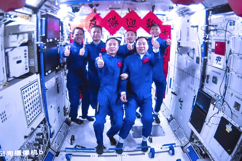 Załogi Shenzhou-15 i Shenzhou-16 robią zdjęcia grupowe wewnątrz głównego modułu Tianhe chińskiej stacji kosmicznej, maj 2023 r.