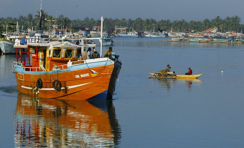 Rybacy ze Sri Lanki stoją na statku rybackim opuszczającym port rybacki w Negombo na obrzeżach Kolombo, październik 2014 r.