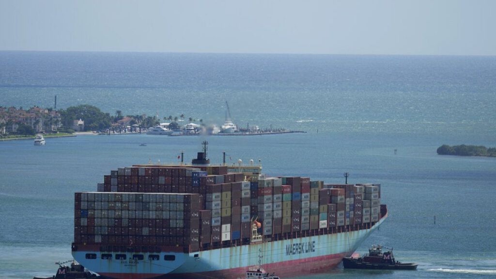 Three tugboats work together to rotate the Axel Maersk container ship as it arrives into port, on Oct. 21, 2021, in Miami.