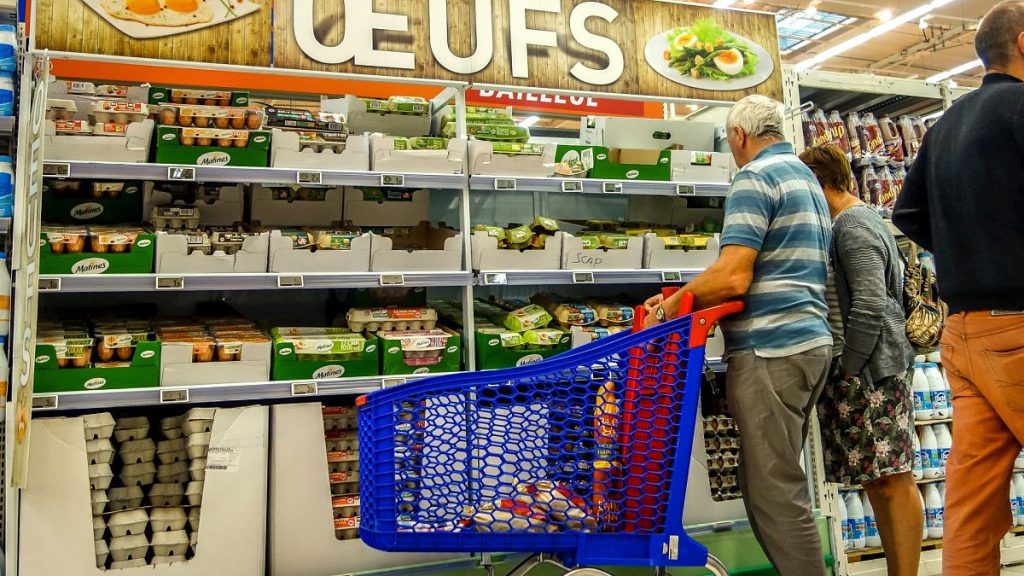 People stand in front of eggs displayed at a supermarket in Lille, on August 11, 2017, as a scandal of eggs contaminated with fipronil spreads across Europe. Nearly 250,000 in