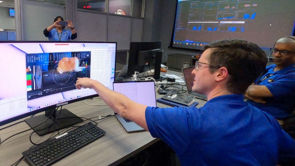 Members of the DSOC team react to the first high-definition streaming video to be sent via laser by the DSOC tranceiver aboard the Psyche spacecraft, nearly 31 million km away