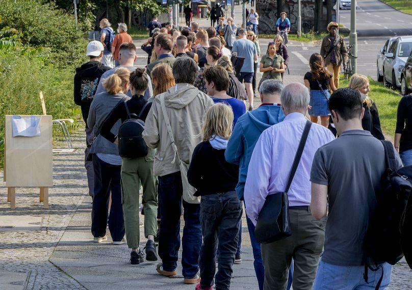 W dniu wyborów ludzie ustawiają się w kolejce przed lokalem wyborczym w berlińskiej dzielnicy Moabit