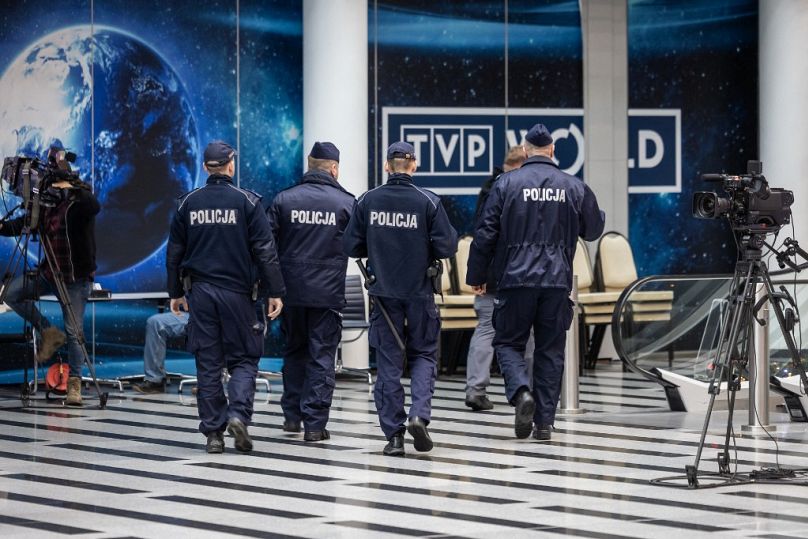 Grupa policjantów wchodzących do siedziby Polskiej Telewizji Publicznej w Warszawie 20 grudnia 2023 r.