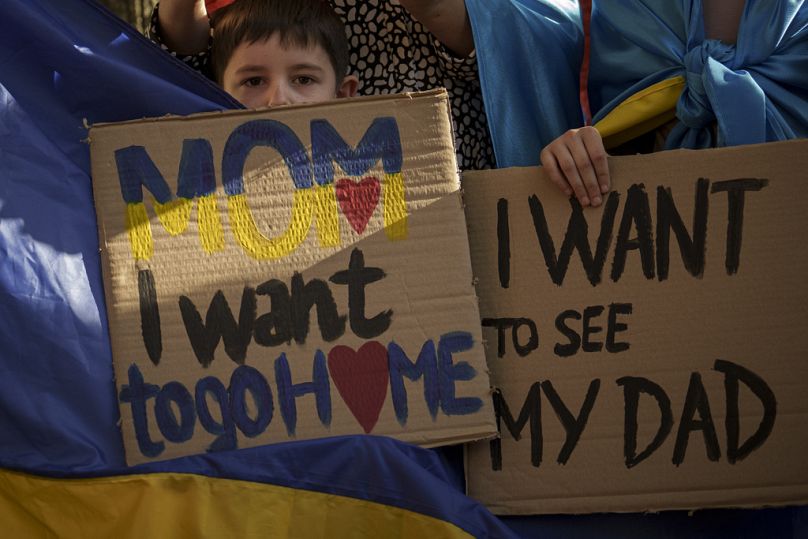 Ukraińskie dzieci trzymają transparenty podczas protestu przed ambasadą Rosji w Bukareszcie, październik 2023 r