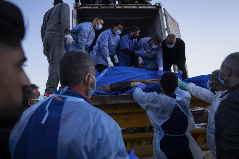 Medycy rozładowują ciała Palestyńczyków zabitych w walkach z Izraelem i przekazanych przez izraelskie wojsko podczas masowego pogrzebu w Rafah w Strefie Gazy, wtorek, 26 grudnia.