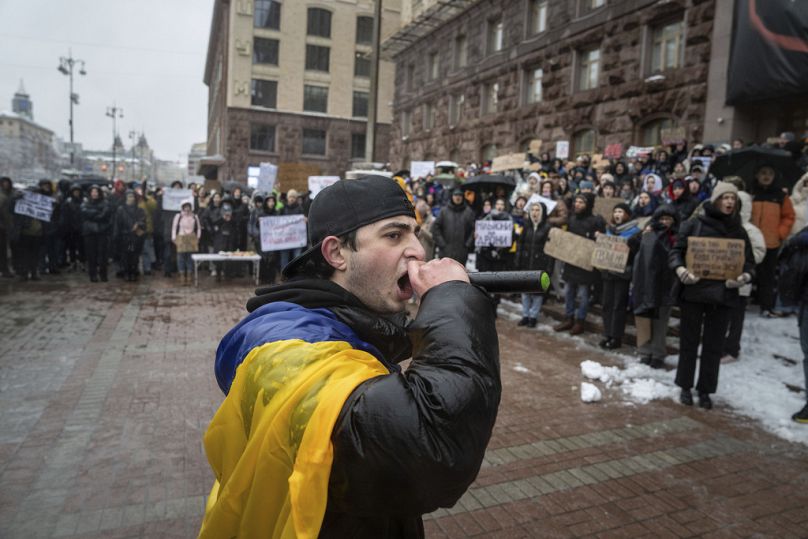 Aktywista krzyczy przez mikrofon podczas protestu przed ratuszem Kijowa