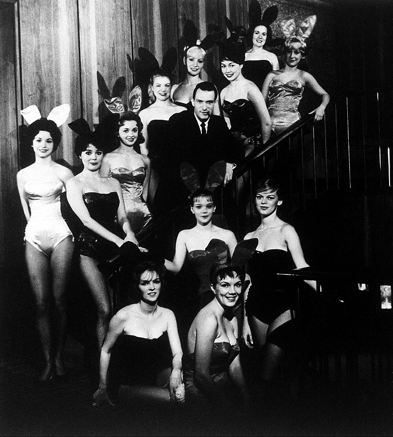 Hugh Hefner, założyciel i prezes Playboy Enterprises, Inc., na zdjęciu wśród grupy króliczków we flagowym klubie Playboy w Chicago, w stanie Illinois, około 1960 r.