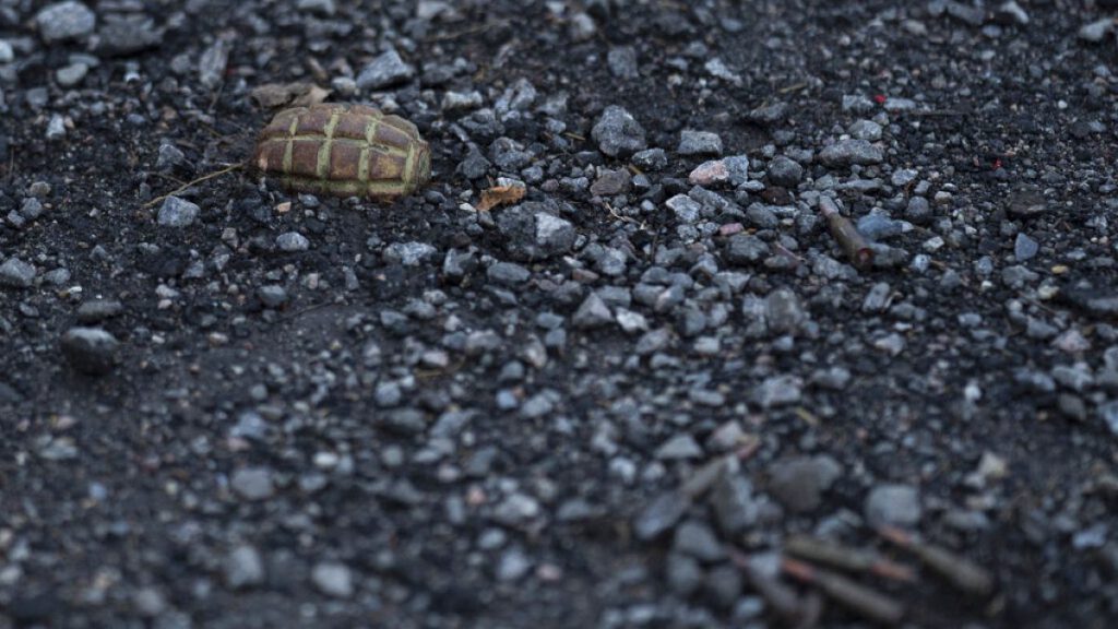 A hand grenade is seen on the road at the entrance of the freed village of Hrakove, Ukraine, Tuesday, Sept. 13, 2022