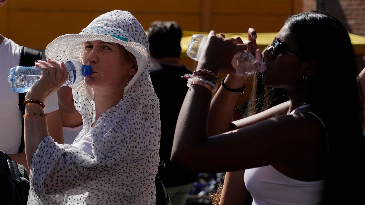 Tourists sips cold water as they shelter from a hot sunny afternoon near the Rome