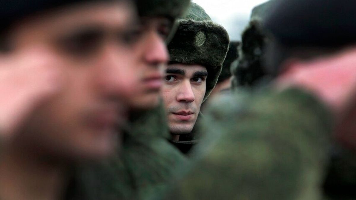 FILE - In this Monday, Nov. 17, 2014, file photo, conscripts stand at a military conscription office in Grozny, Chechnya