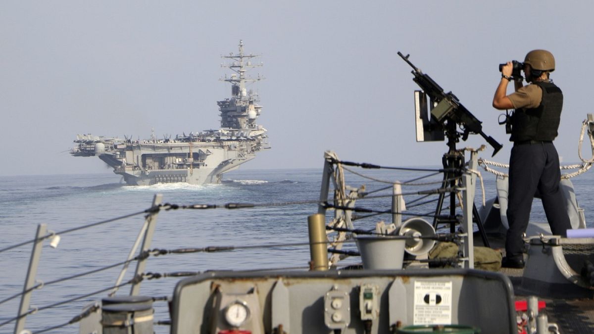 The aircraft carrier USS Dwight D. Eisenhower and other warships including the USS GRAVELY cross the Strait of Hormuz into the Persian Gulf in November