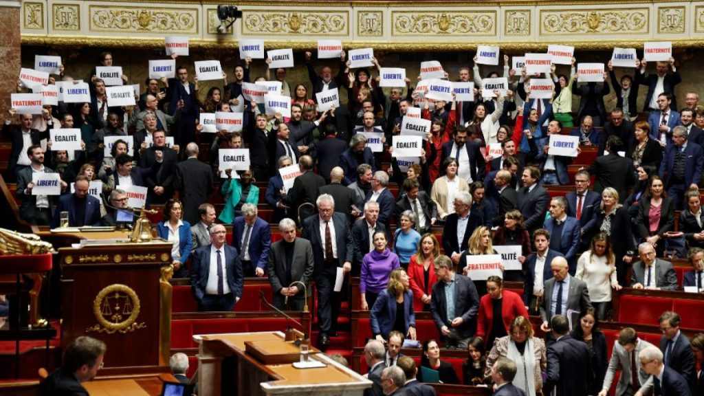 Left-wing coalition NUPES members of parliament hold signs reading