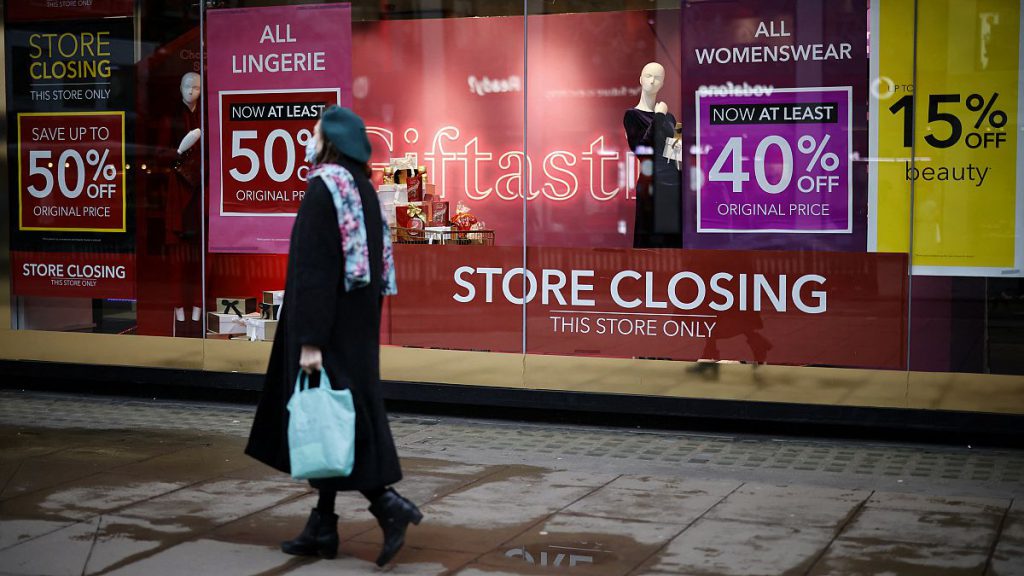Pedestrians walk past the window display of a Debenhams shop on Oxford Street in central London on December 22, 2020.
