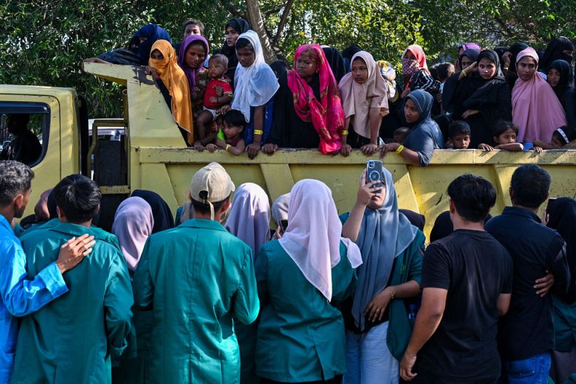 Uchodźcy Rohingya wpychają się do pojazdu, aby przenieść się do pobliskiego budynku rządowego po tym, jak demonstrujący studenci zmusili ich do opuszczenia tymczasowego domu