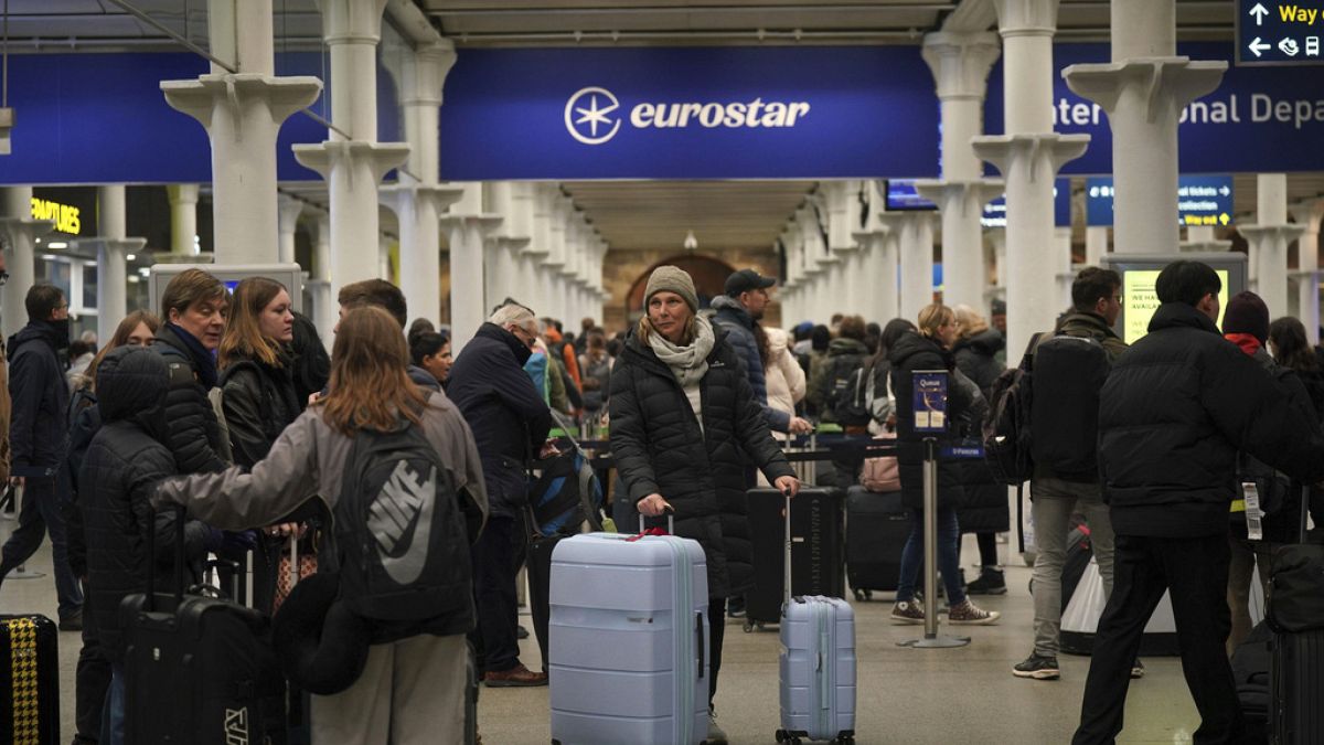 Passengers queue at the entrance to Eurostar in St Pancras International station in central London on Sunday