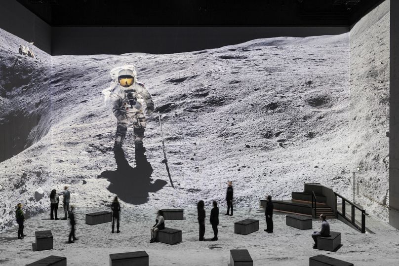 Widzowie biorą udział w wystawie „Wędrowcy księżycowi: podróż z Tomem Hanksem” w Lightroom w Londynie.
