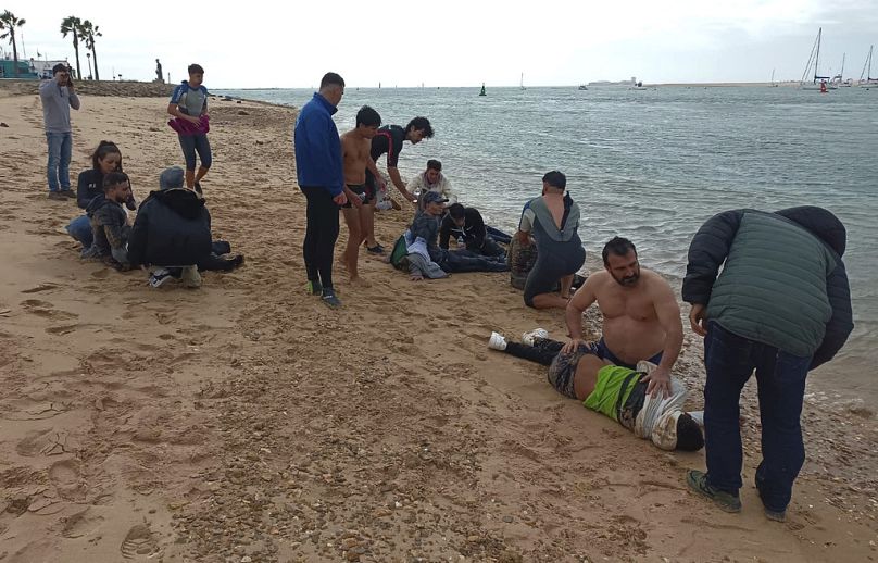 Migranci są ratowani przez mieszkańców na brzegu plaży w pobliżu południowo-zachodniego miasta Kadyks w Hiszpanii.