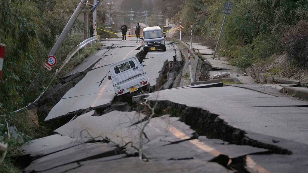 Bystanders look at damages somewhere near Noto town in the Noto peninsula facing the Sea of Japan, northwest of Tokyo, Tuesday, Jan. 2, 2024