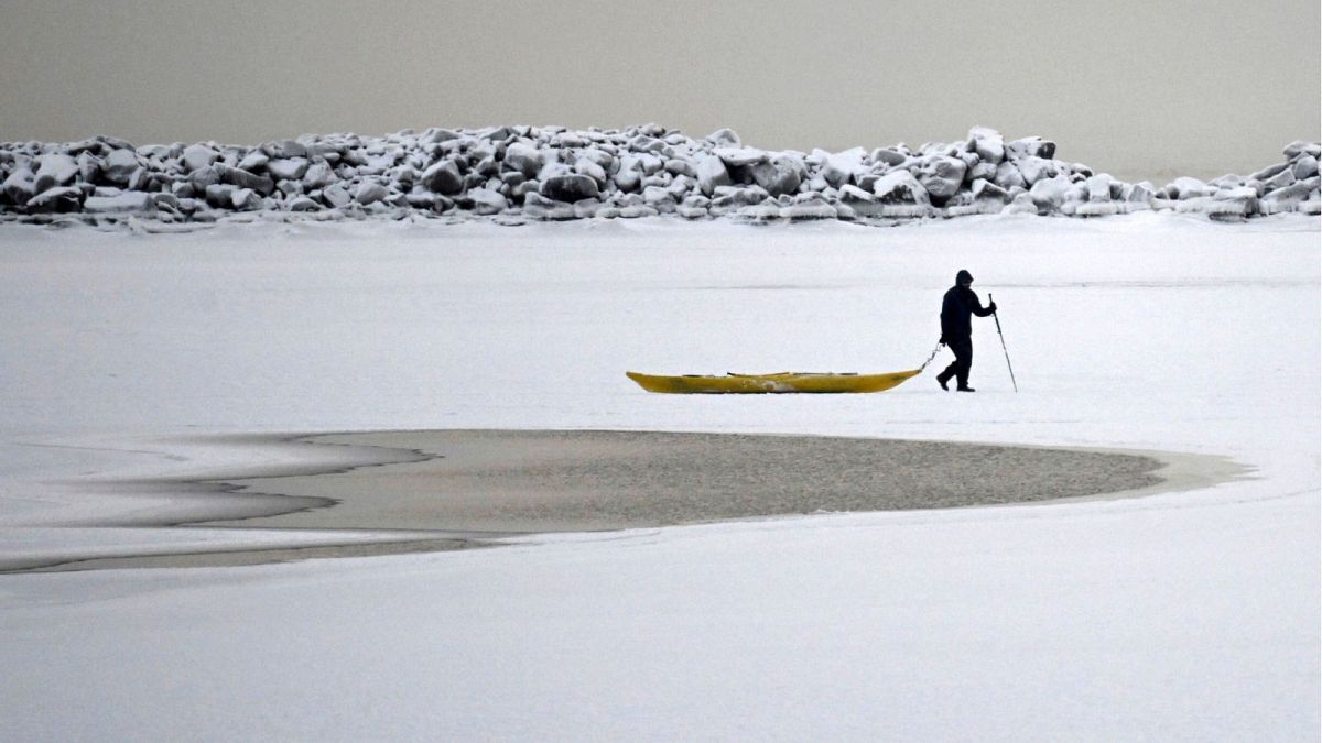 A man walks on the frozen sea in southern Helsinki, Finland, Tuesday, Jan. 2, 2024.