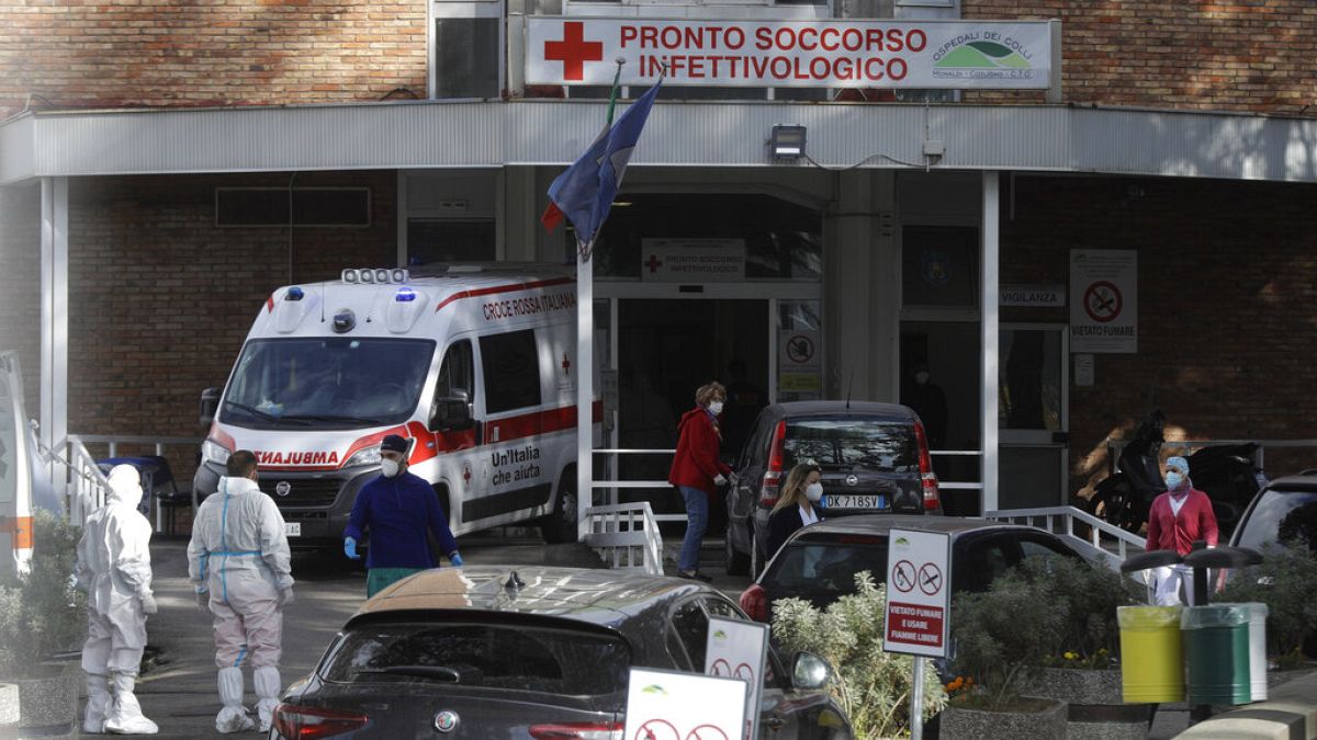 FILE- Paramedics and ambulances stand outside the first aid department of the Cotugno hospital in Naples, Italy, Friday, Nov. 13, 2020.