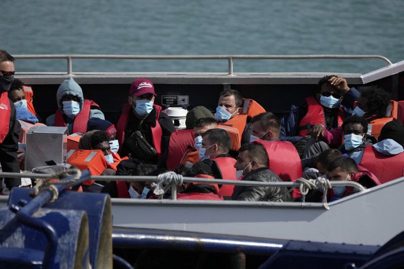 Migranci i osoby ubiegające się o azyl czekają na opuszczenie statku brytyjskiej służby granicznej w Dover, czerwiec 2022 r.