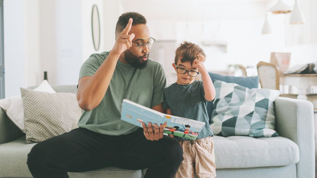 A man teaches a boy BSL