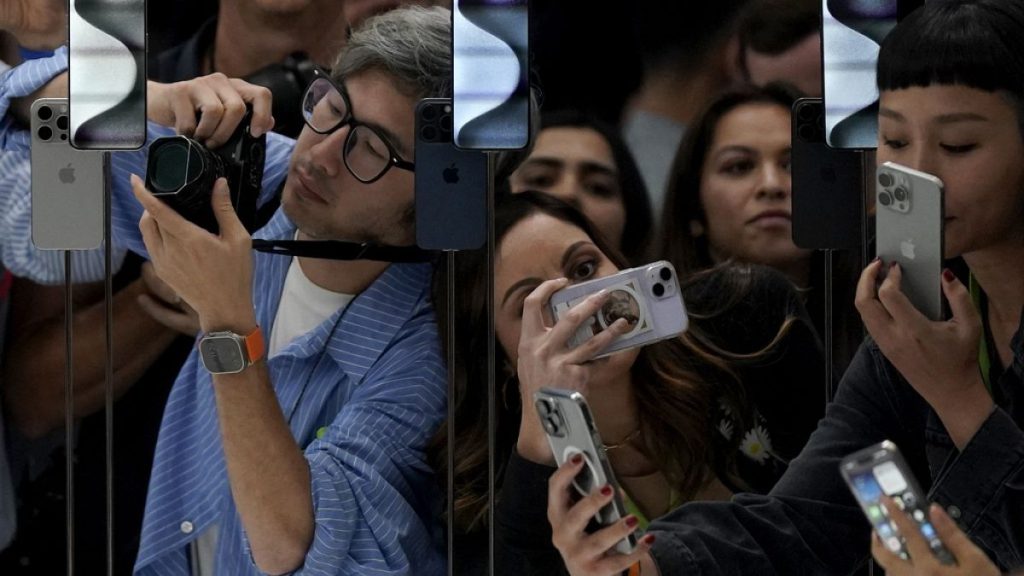 People take photos of the iPhone 15 Pro phones during an announcement of new products on the Apple campus in Cupertino, Calif., Tuesday, Sept. 12, 2023