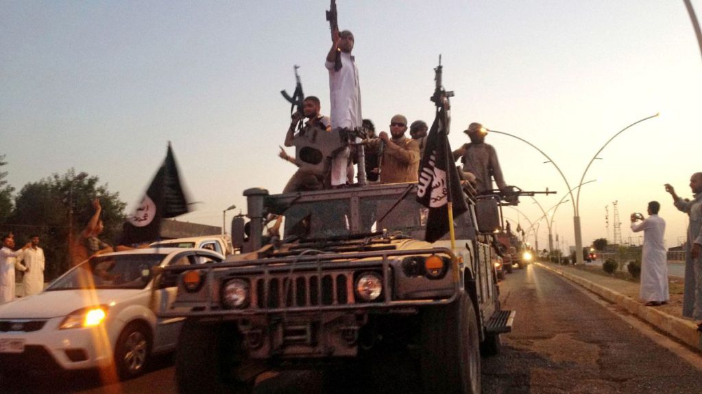 In this June 23, 2014 file photo, fighters from the Islamic State group parade in a commandeered Iraqi security forces armored vehicle in the northern city of Mosul, Iraq.