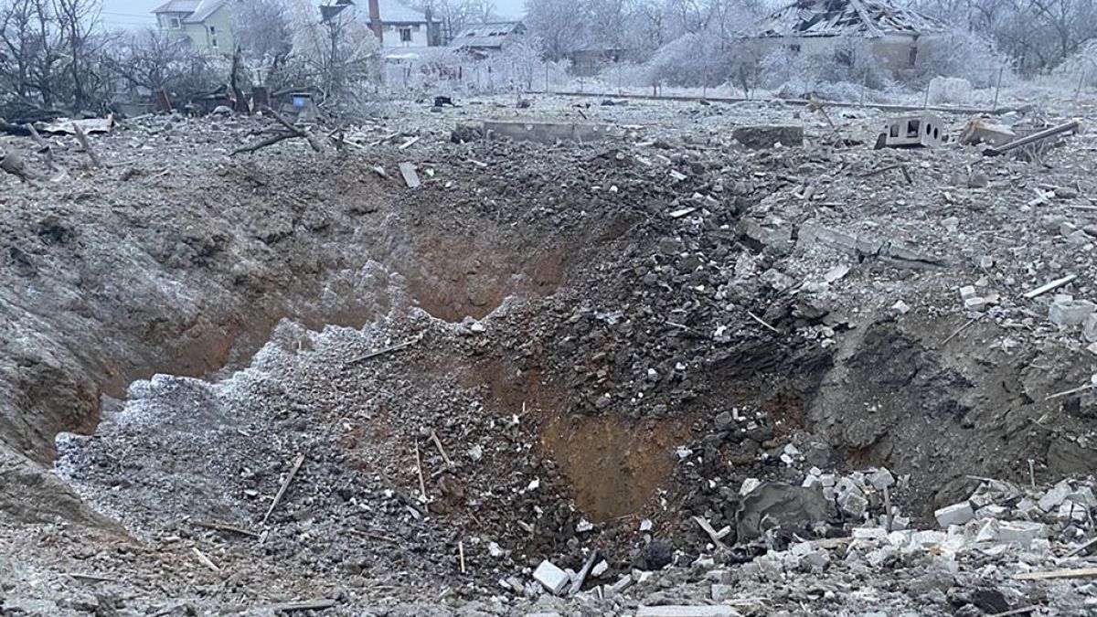 a crater of an explosion is seen next to the private building destroyed after a Russian missile attack in Novomoskovsk, near Kryvyi Rih, Ukraine, Monday, Jan. 8, 2024.