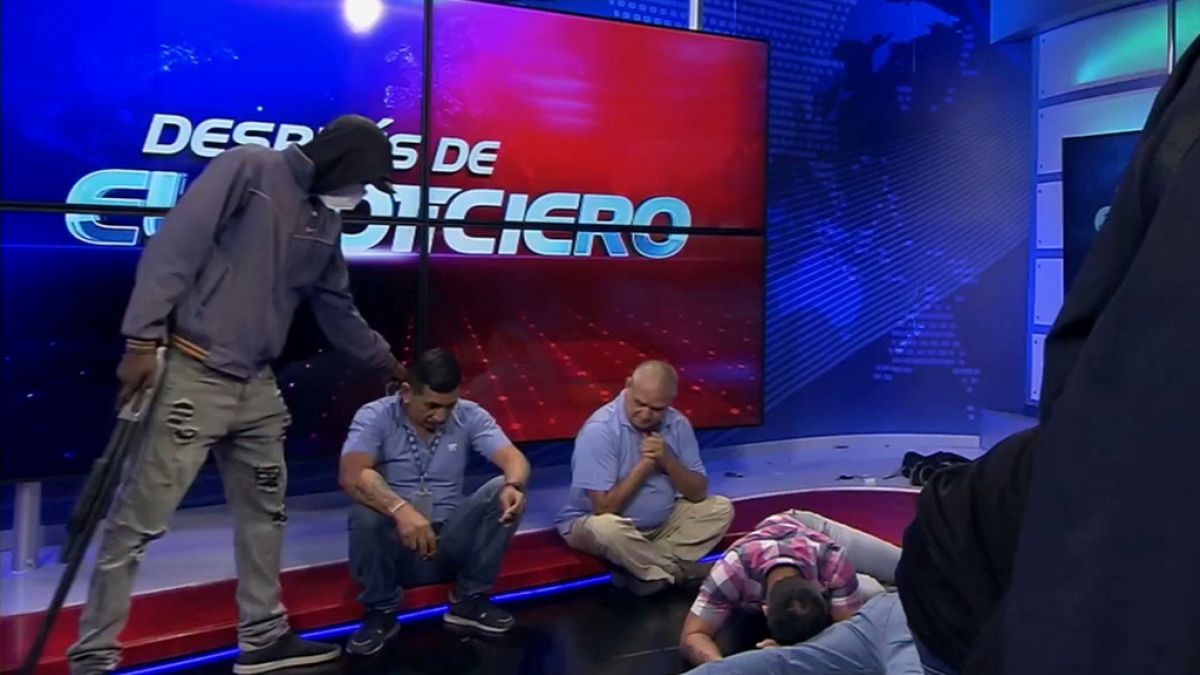 This screen grab of live video from the TC Television network shows a masked, armed person standing over journalists during a live broadcast, in Guayaquil, Ecuador, 9/1/24.