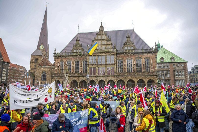 Protestujący przed ratuszem w Bremie podczas wiecu DGB, domagający się lepszych szkoleń w dziedzinach zdominowanych przez kobiety i przeciwdziałania różnicom w wynagrodzeniach kobiet i mężczyzn w celu zwalczania niedoborów umiejętności.  Marzec 2023