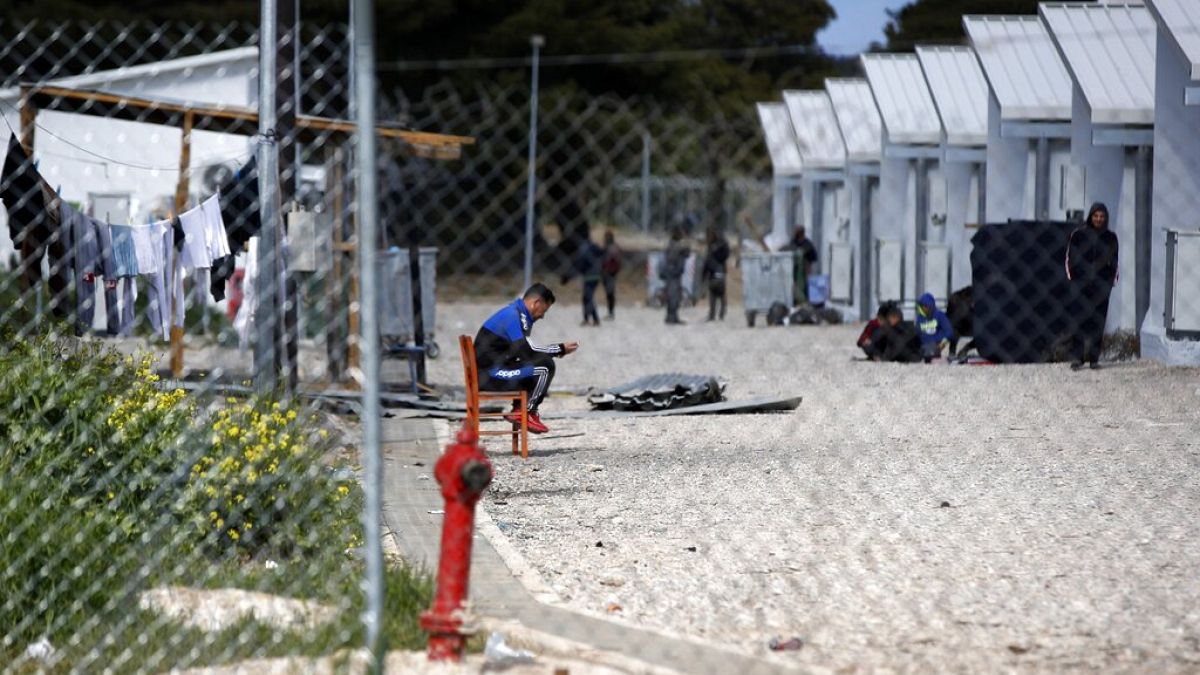 FILE - Migrants gather outside their container houses t a refugee camp in Ritsona about 80 kilometers (50 miles) north of Athens, Thursday, April 2, 2020.