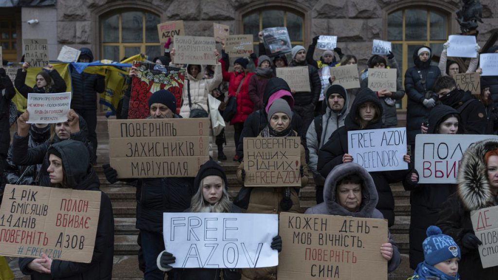 People hold posters reading