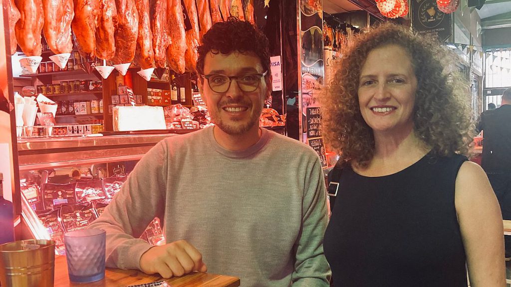 Oscar and Aileen sharing a plate of payoyo cheese and discussing pig legs