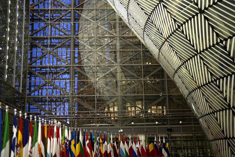 Flagi Unii Europejskiej na czerwonym dywanie w strefie przylotów podczas posiedzenia w budynku Rady Europejskiej w Brukseli, grudzień 2023 r.