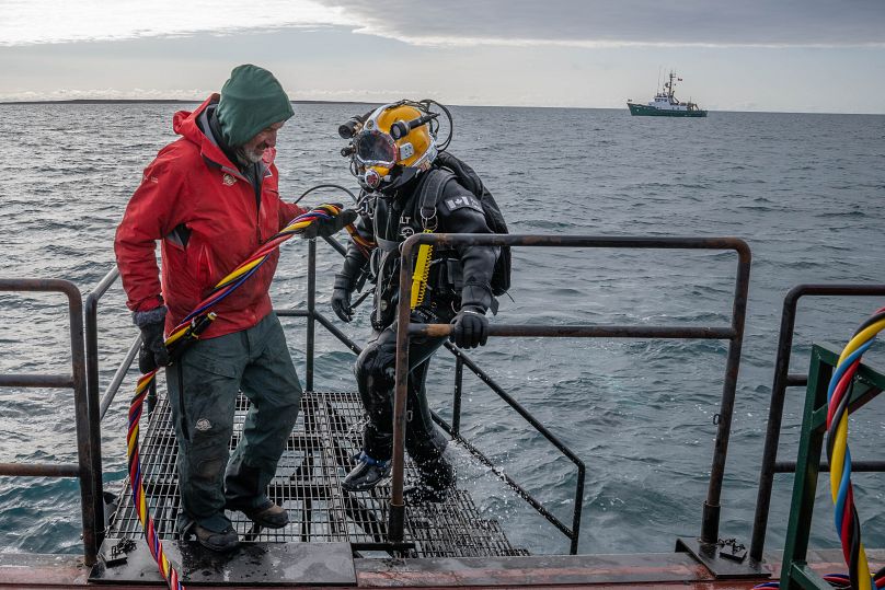 Technik archeologii podwodnej Todd Stakenvicius wraca na barkę pomocniczą po nurkowaniu na HMS Erebus z kamperem Davidem Thompsonem w tle, 6 września 2023 r.